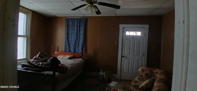 bedroom featuring multiple windows, a ceiling fan, and a paneled ceiling
