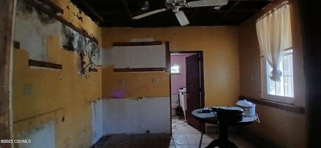 interior space with a ceiling fan and light tile patterned floors