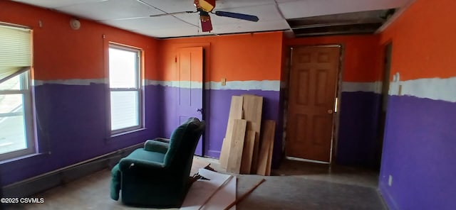 sitting room with a ceiling fan and a paneled ceiling