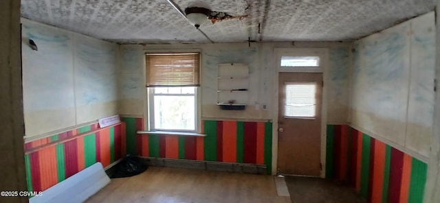 spare room featuring wood finished floors and wallpapered walls