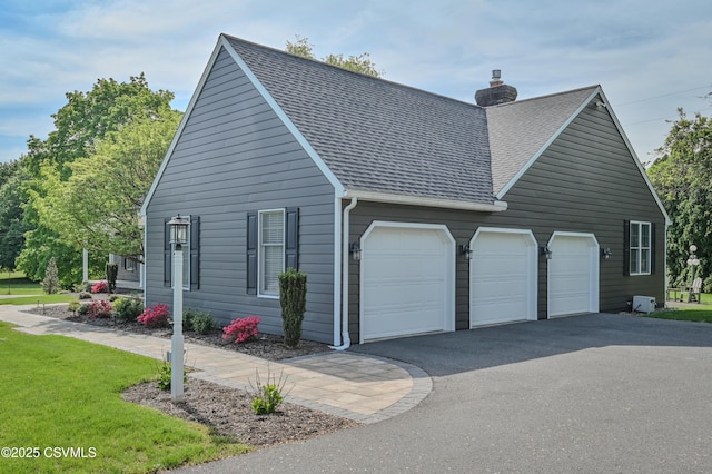 view of property exterior featuring a shingled roof, a chimney, driveway, and a garage