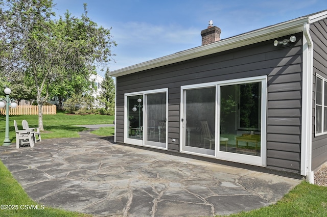 rear view of property with a patio and a chimney
