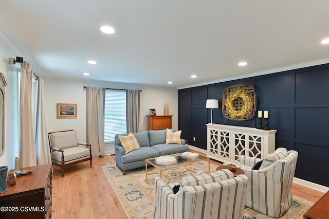 living room featuring light wood-style floors, recessed lighting, ornamental molding, and a decorative wall