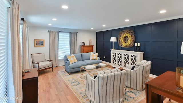 living area with recessed lighting, light wood-style floors, and a decorative wall