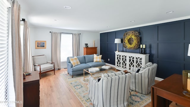 living room featuring light wood finished floors, crown molding, and recessed lighting