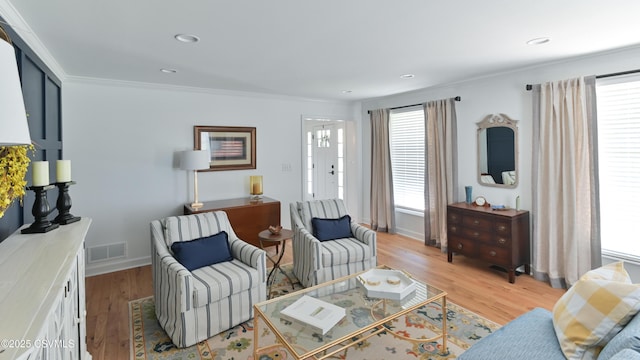 living room featuring ornamental molding, healthy amount of natural light, light wood-style flooring, recessed lighting, and baseboards