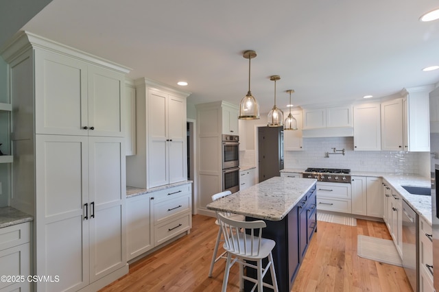 kitchen with stainless steel appliances, a center island, white cabinetry, decorative backsplash, and recessed lighting