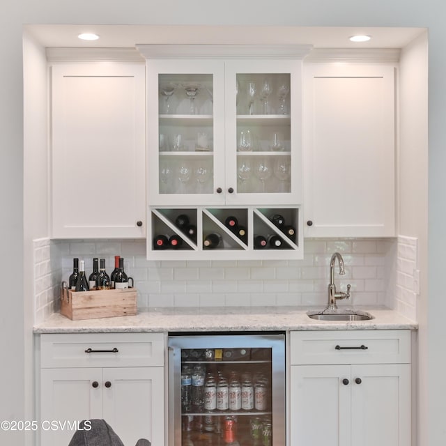 indoor wet bar featuring wine cooler and tasteful backsplash