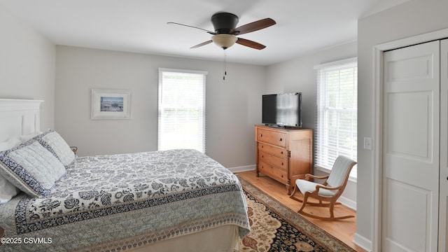 bedroom featuring wood finished floors, baseboards, and ceiling fan