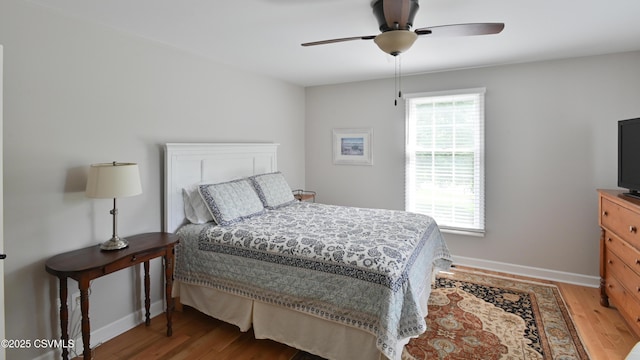 bedroom with baseboards, light wood-style floors, and a ceiling fan