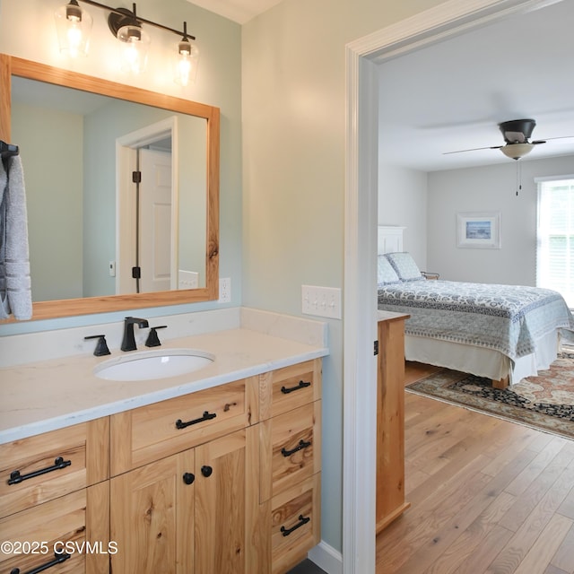 bathroom featuring wood finished floors, a ceiling fan, and vanity