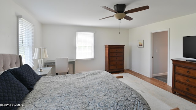 bedroom with wood finished floors, baseboards, and a ceiling fan