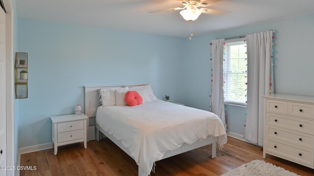 bedroom featuring light wood-style floors, baseboards, and ceiling fan