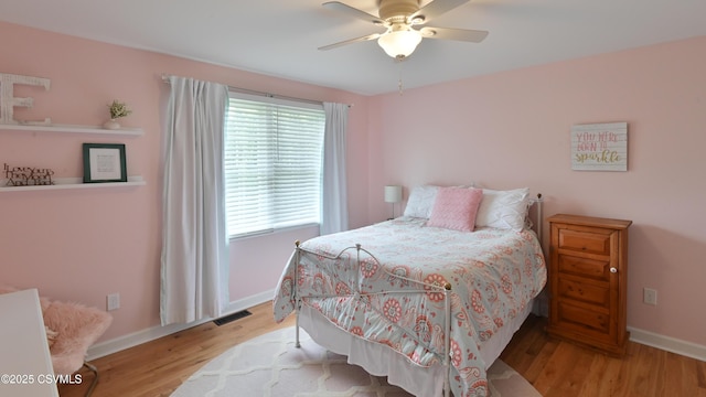 bedroom with wood finished floors, baseboards, and ceiling fan