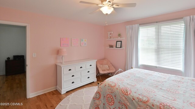 bedroom with light wood-style floors, baseboards, and a ceiling fan