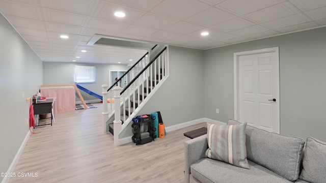 living area featuring recessed lighting, wood finished floors, baseboards, and stairway