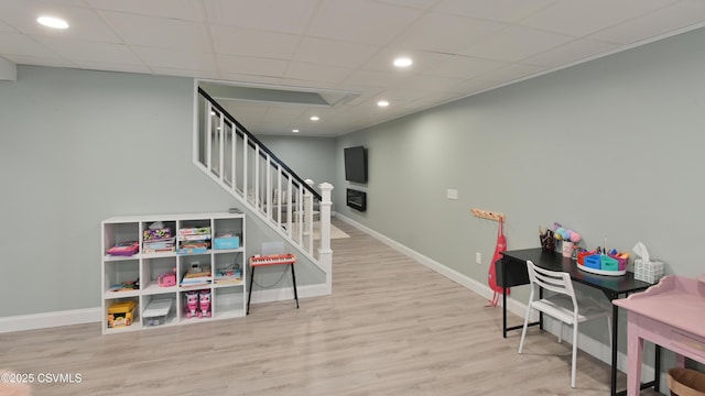 playroom featuring wood finished floors, baseboards, recessed lighting, and a paneled ceiling