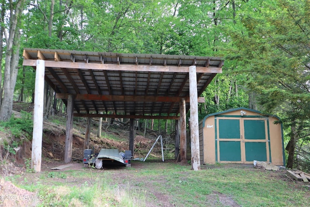 view of vehicle parking with a storage shed and a detached carport