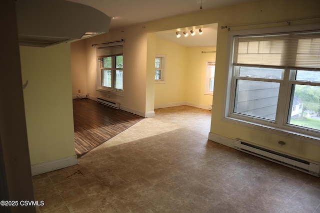 empty room with a baseboard heating unit and baseboards