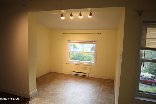 empty room with a baseboard radiator, healthy amount of natural light, and baseboards