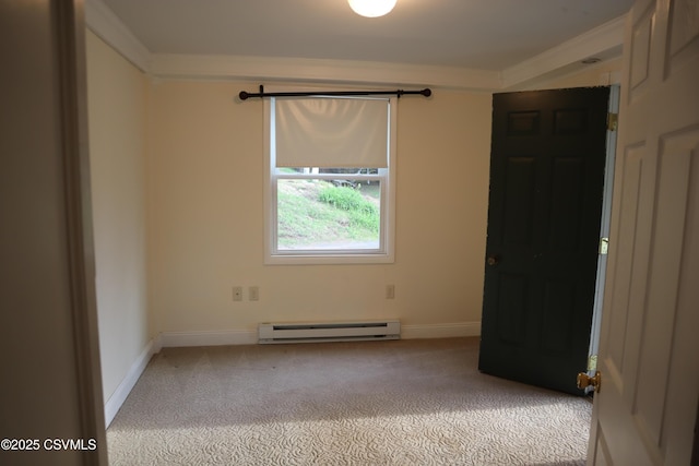 empty room with baseboard heating, light colored carpet, crown molding, and baseboards