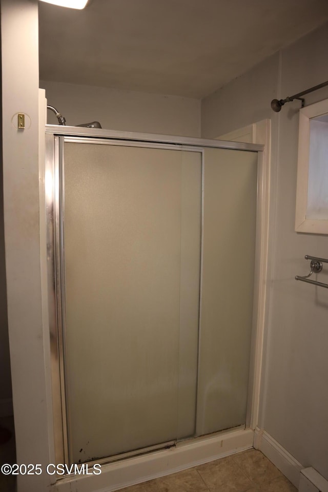 bathroom with a shower stall and tile patterned floors