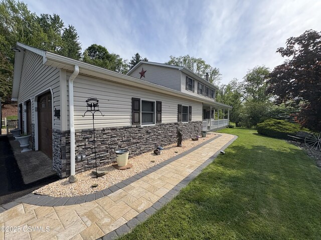 34 Fowlersville Rd, Bloomsburg, PA 17815 - view of side of home with stone siding, a yard, and an attached garage