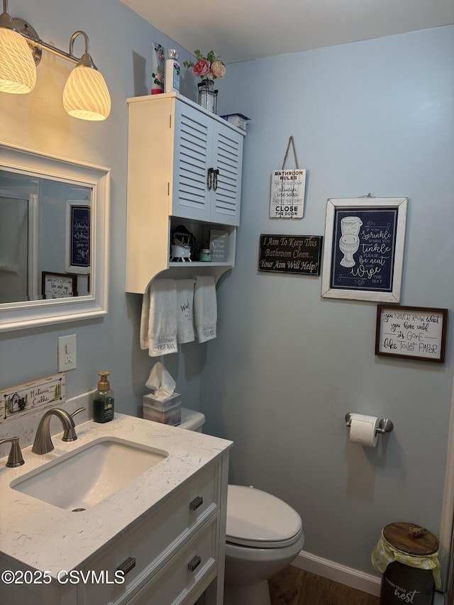 34 Fowlersville Rd, Bloomsburg, PA 17815 - bathroom with toilet, vanity, wood finished floors, and baseboards