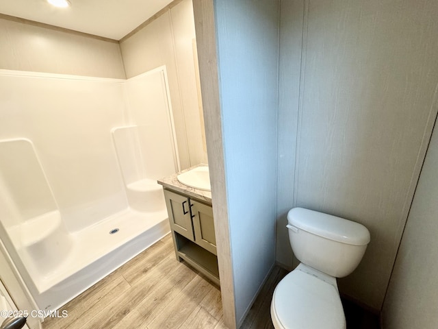 full bathroom with wood finished floors, toilet, a shower stall, and vanity