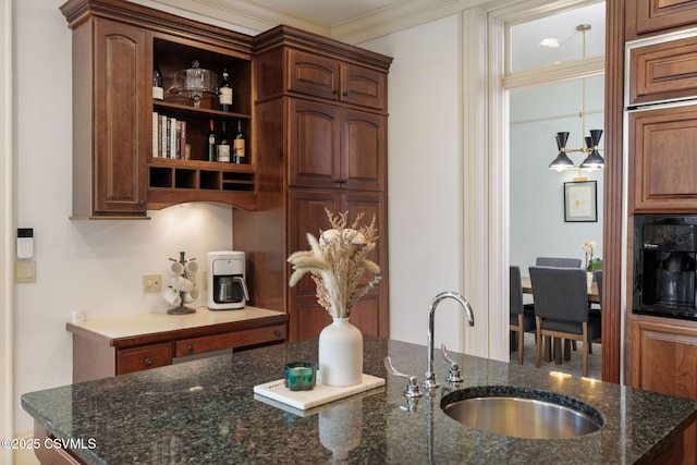 kitchen with a sink, dark stone countertops, ornamental molding, and open shelves