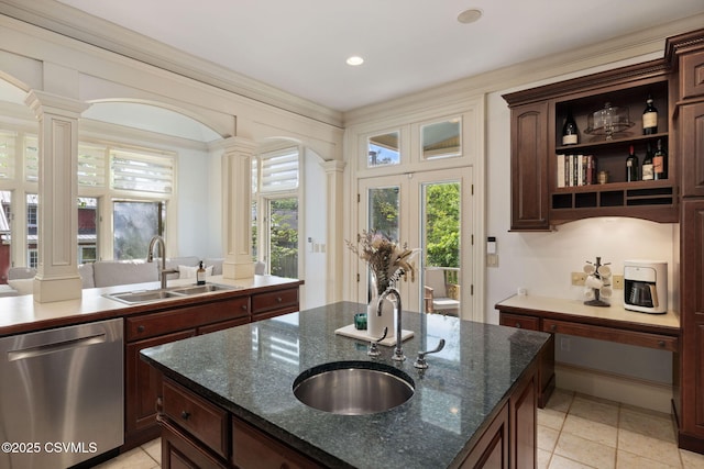 kitchen featuring stainless steel dishwasher, decorative columns, a sink, and recessed lighting