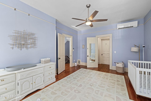 bedroom with dark wood-type flooring, a wall mounted AC, a ceiling fan, and baseboards