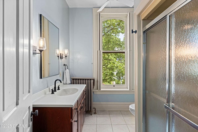 bathroom with tile patterned flooring, vanity, healthy amount of natural light, and radiator heating unit