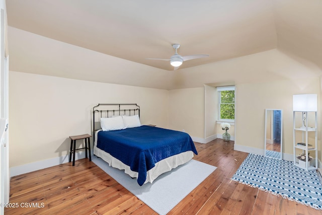 bedroom with light wood-style flooring, baseboards, lofted ceiling, and a ceiling fan