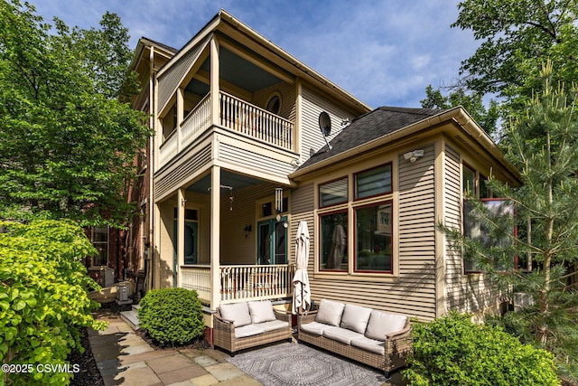 rear view of house with a balcony, an outdoor hangout area, and a porch
