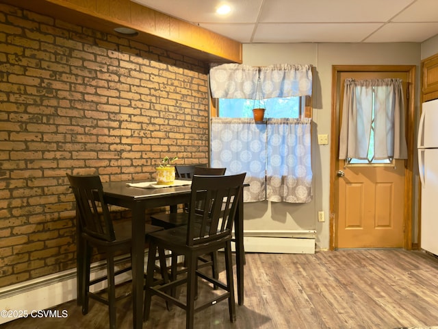 303 Melrose St, Marion Heights, PA 17832 - dining room featuring a paneled ceiling, wood finished floors, baseboards, brick wall, and healthy amount of natural light