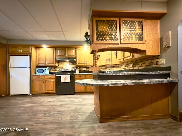 303 Melrose St, Marion Heights, PA 17832 - kitchen with white appliances, under cabinet range hood, dark countertops, backsplash, and brown cabinetry