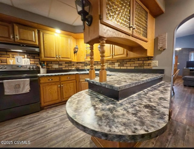 303 Melrose St, Marion Heights, PA 17832 - kitchen with black range with electric stovetop, arched walkways, dark countertops, backsplash, and wood finished floors