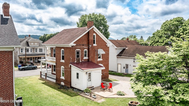 206 Orange St, Selinsgrove, PA 17870 - back of property featuring a chimney, brick siding, a lawn, and a patio area