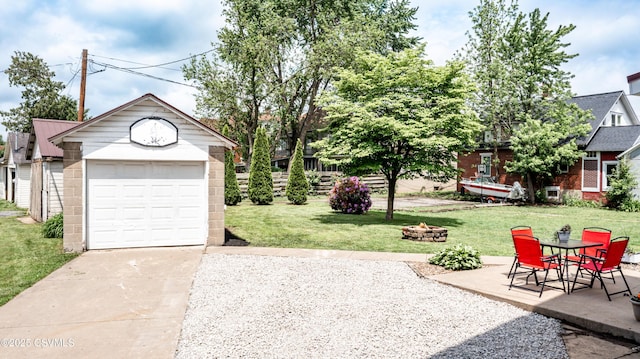 206 Orange St, Selinsgrove, PA 17870 - view of grassy yard with a fire pit, concrete driveway, and a detached garage