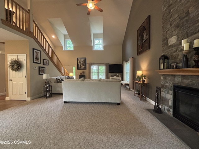 1874 Reading Tpke, Elysburg, PA 17824 - carpeted living area with a towering ceiling, a stone fireplace, a ceiling fan, healthy amount of natural light, and baseboards