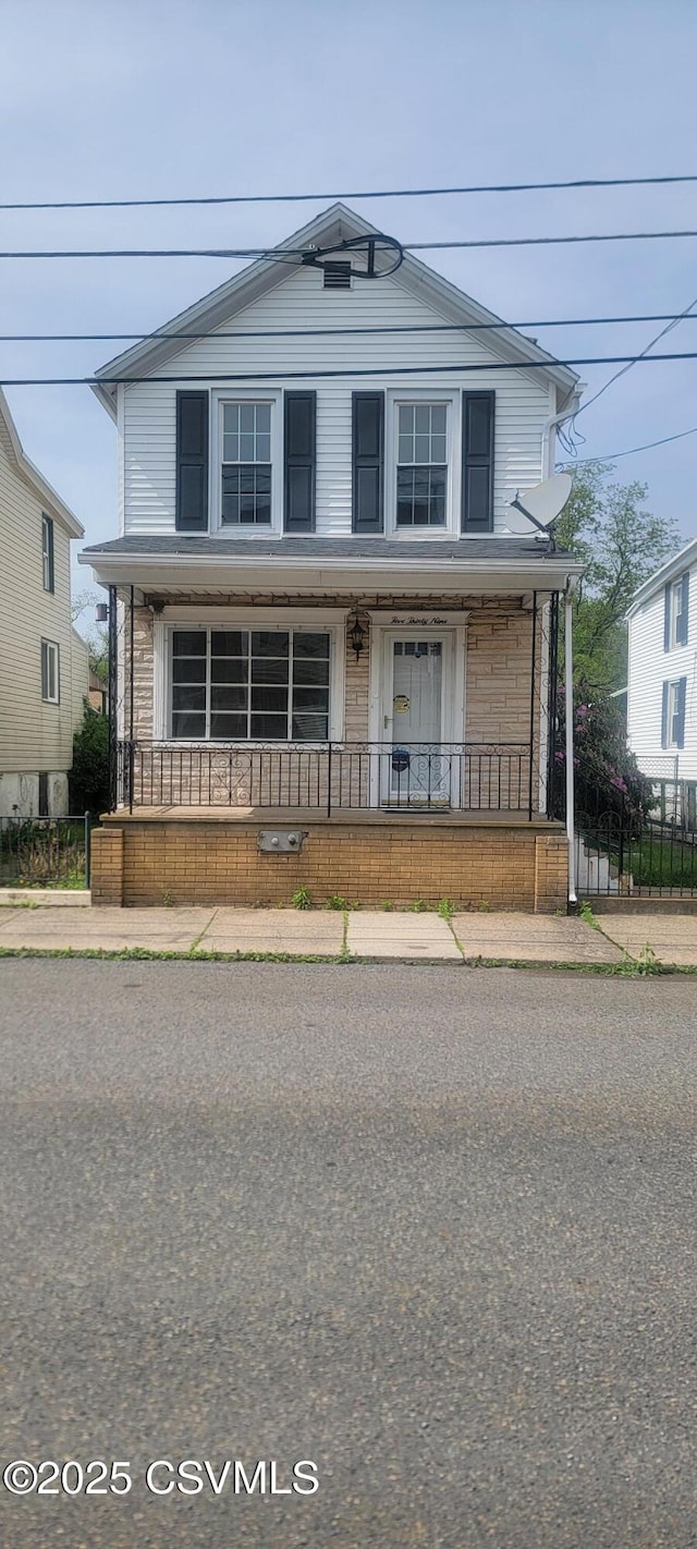 view of front facade with covered porch and fence