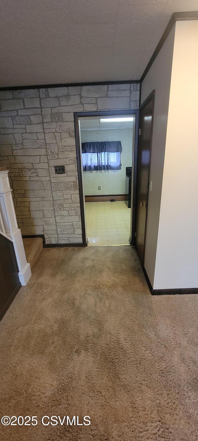 hallway featuring carpet floors and baseboards