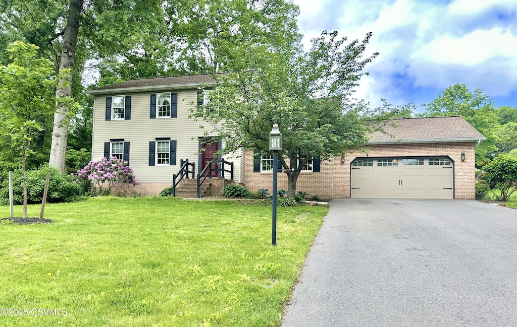 32 Lost Creek Dr, Selinsgrove, PA 17870 - colonial inspired home with asphalt driveway, a front lawn, an attached garage, and brick siding