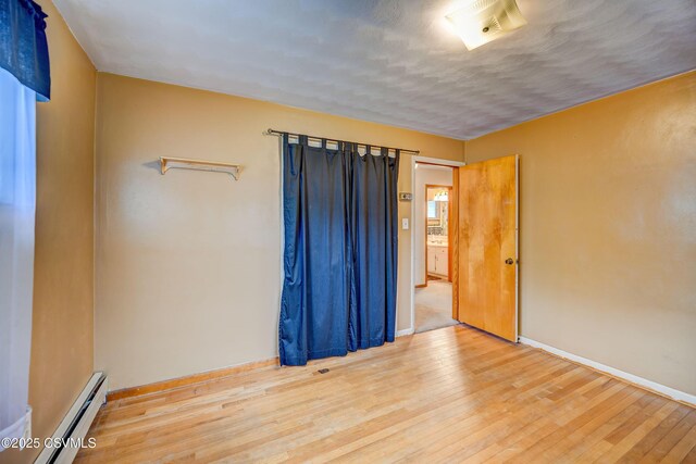 1030 Ruthann Dr, Berwick, PA 18603 - empty room featuring baseboard heating, hardwood / wood-style floors, and baseboards