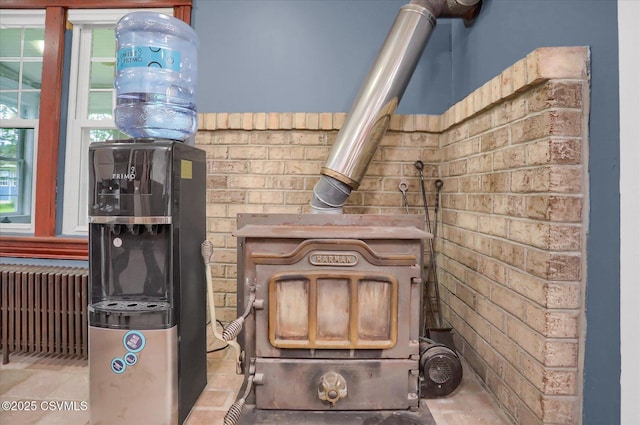 288 Broadway St, Turbotville, PA 17772 - detailed view of radiator heating unit, brick wall, and a wood stove