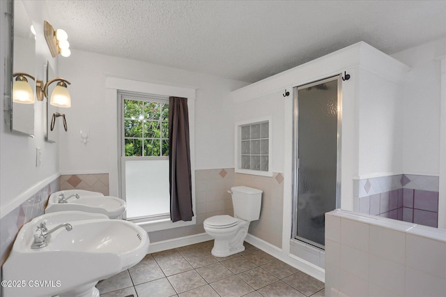 288 Broadway St, Turbotville, PA 17772 - bathroom with tile walls, toilet, tile patterned flooring, a stall shower, and a wainscoted wall