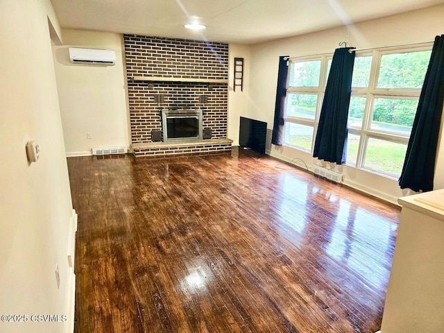 43 Red Oak Dr, Danville, PA 17821 - unfurnished living room with a wall mounted AC, wood finished floors, a fireplace, and plenty of natural light