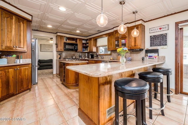 937 E 10th St, Berwick, PA 18603 - kitchen featuring stainless steel appliances, tasteful backsplash, brown cabinets, a peninsula, and an ornate ceiling