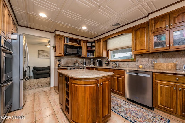 937 E 10th St, Berwick, PA 18603 - kitchen featuring appliances with stainless steel finishes, open shelves, brown cabinetry, backsplash, and an ornate ceiling